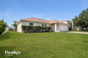 Kissimmee house for rent - a white house with a lawn in front of it
