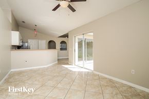 Kissimmee house for rent - an empty living room with a sliding glass door to the kitchen