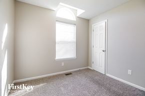 Raymore house for rent - a bedroom with a white door and a window and a carpeted floor