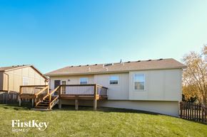 Raymore house for rent - the exterior of a white manufactured home with a deck and a porch