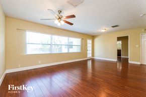 Winter Park house for rent - A spacious room with a ceiling fan and wooden flooring.
