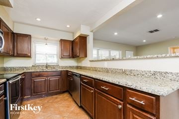 Winter Park house for rent - A kitchen with brown cabinets and a granite countertop.