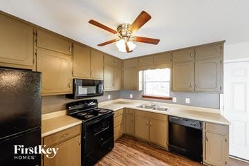 Birmingham house for rent - a kitchen with white cabinets and black appliances and a ceiling fan