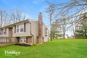 Greenwood house for rent - a house with a brick chimney on the side of a green lawn