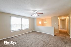 Greenwood house for rent - an empty living room with a ceiling fan and a large window
