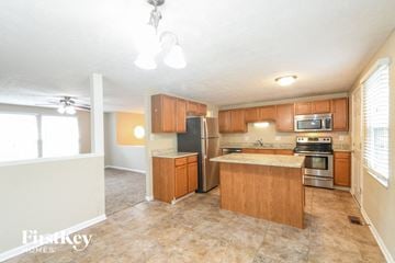 Greenwood house for rent - a kitchen with wooden cabinets and stainless steel appliances