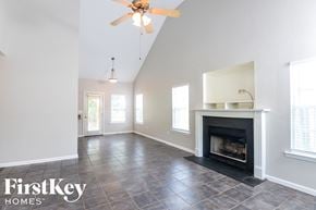 Calera house for rent - a living room with a fireplace and a ceiling fan