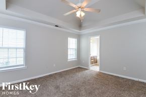 Calera house for rent - the master bedroom has a ceiling fan and carpeted flooring