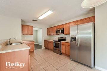 Clermont house for rent - a kitchen with stainless steel appliances and wooden cabinets