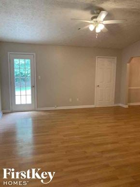 Jonesboro house for rent - A room with wooden floors and a ceiling fan.