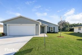 Port St. Lucie house for rent - a white house with a lawn and a white garage door