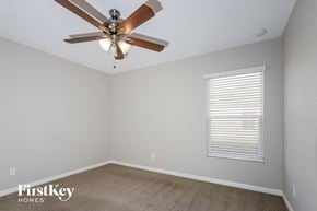 Port St. Lucie house for rent - a bedroom with a ceiling fan and a window