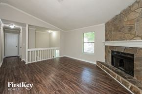 Lilburn house for rent - a living room with a stone fireplace and wooden floors