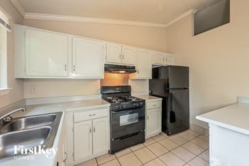 Lilburn house for rent - a kitchen with white cabinets and black appliances