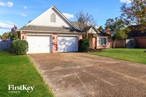 Cordova house for rent - A house with a driveway and a garage door.