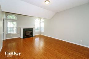 Cordova house for rent - A large empty room with a fireplace and wood flooring.
