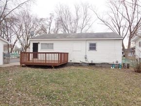 Wauconda house for rent - a small white house with a wooden deck in a yard