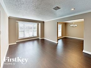 Conroe house for rent - an empty living room with wood floors and a large window