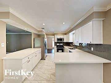 Conroe house for rent - a large white kitchen with white counters and white cabinets