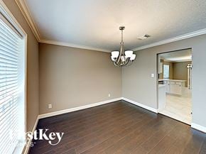 Conroe house for rent - an empty dining room with wood flooring and a chandelier