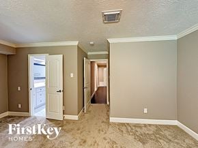 Conroe house for rent - a bedroom with a door to a hallway and a closet