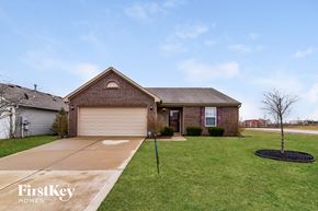 Greenwood house for rent - a brick house with a lawn and a driveway