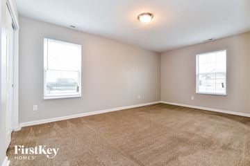Greenwood house for rent - the living room of a house with carpet and two windows
