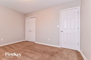 Greenwood house for rent - a bedroom with two doors and a carpeted floor