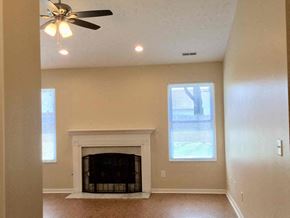 Cincinnati house for rent - a living room with a fireplace and a ceiling fan