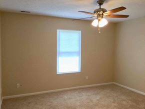 Cincinnati house for rent - a bedroom with a ceiling fan and a window