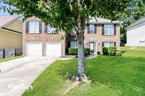 Jonesboro house for rent - a large brick house with two garage doors and a tree in the front