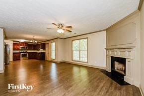 Jonesboro house for rent - an empty living room with a fireplace and wooden floors