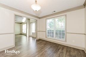 Jonesboro house for rent - a living room and dining room with wood floors and a large window
