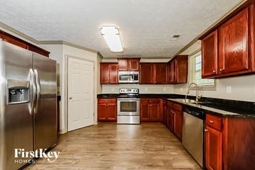 Jonesboro house for rent - a kitchen with wooden cabinets and stainless steel appliances