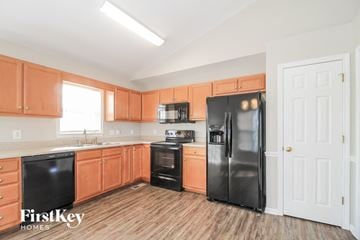 High Point house for rent - a kitchen with wooden floors and black appliances