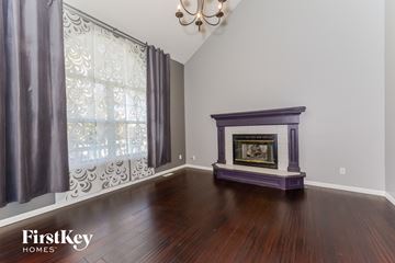 Raymore house for rent - a living room with a fireplace and a window with curtains