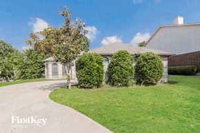Mckinney house for rent - A house with a driveway and a tree in front of it.