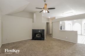 Mckinney house for rent - A spacious living room with a fireplace and a ceiling fan.