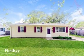 New Whiteland house for rent - A yellow house with red trim and a red awning is for sale.