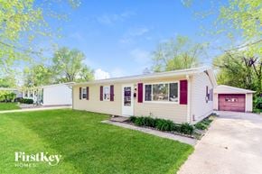 New Whiteland house for rent - A white house with a red door is surrounded by green grass.