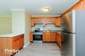 New Whiteland house for rent - A kitchen with wooden cabinets and a stainless steel refrigerator.