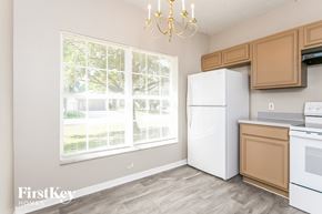 Kissimmee house for rent - a kitchen with a large window and a white refrigerator