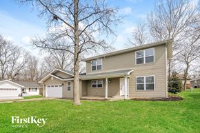 Lake Saint Louis house for rent - A beige house with a tree in front of it.