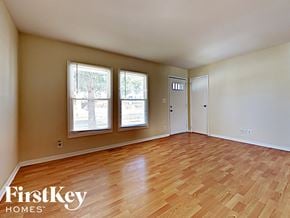 Streamwood house for rent - an empty living room with wood flooring and three windows
