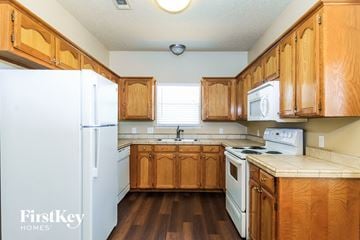 Arlington house for rent - a kitchen with white appliances and wooden cabinets