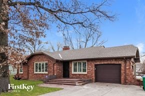 Kansas City house for rent - a red brick house with a black garage door