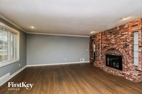 Kansas City house for rent - the living room of a house with a brick fireplace