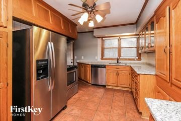Kansas City house for rent - a kitchen with stainless steel appliances and wooden cabinets