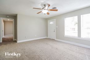 Baytown house for rent - A spacious room with a ceiling fan and two doors.