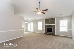 Woodstock house for rent - a living room with a fireplace and a ceiling fan